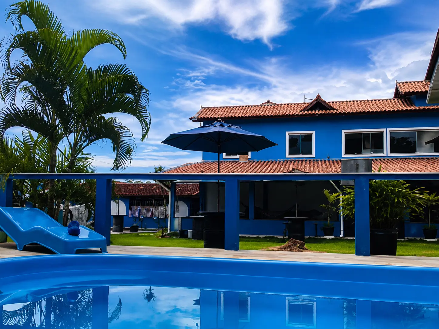 Piscina com palmeiras e céu azul