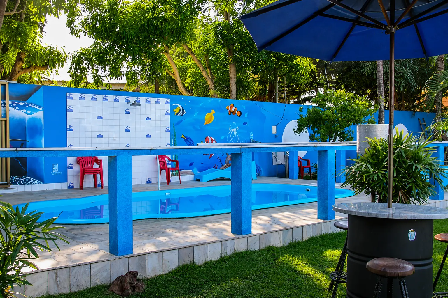Piscina da pousada com mural de peixes coloridos