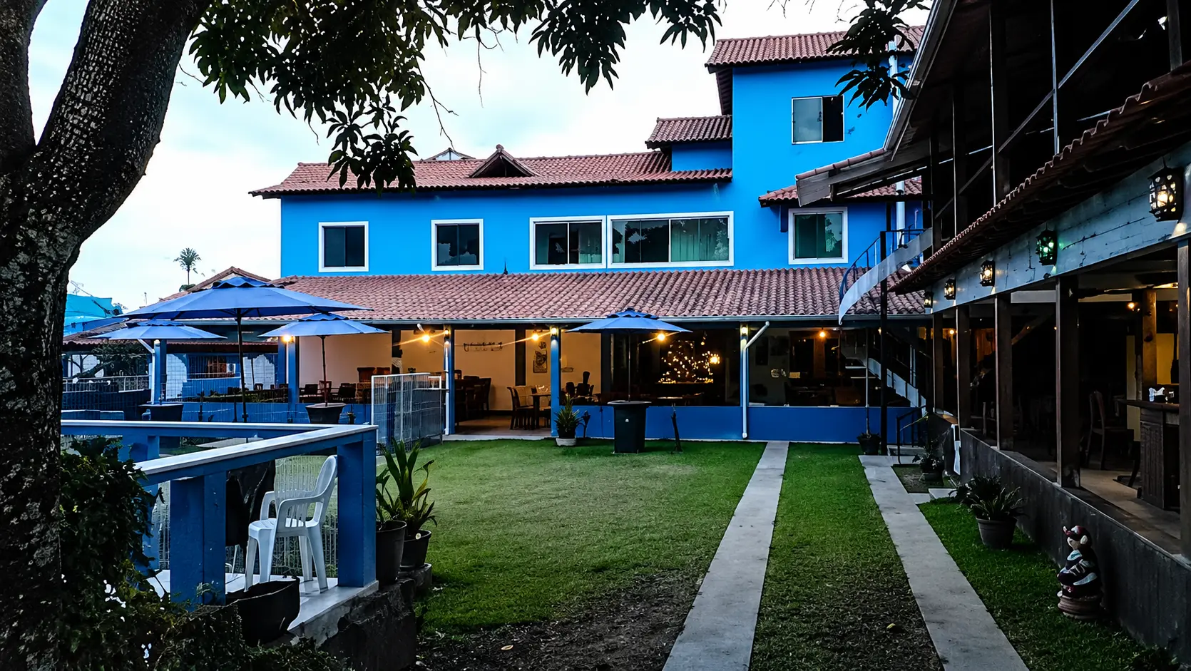 Fachada azul da Pousada Paraíso Azul ao entardecer